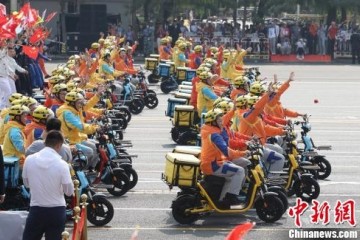 快递小哥亮相群众游行电动车实现低碳出行